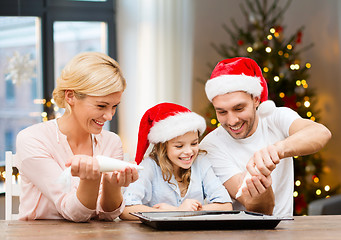 Image showing family decorating bakery by frosting on christmas