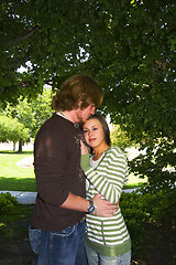 Image showing Young couple hugging under the trees in a park