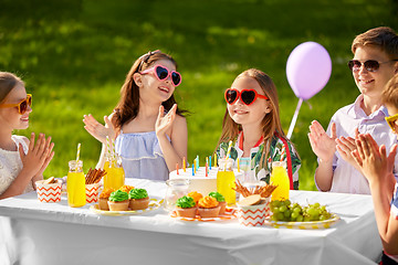 Image showing happy kids with cake on birthday party in summer