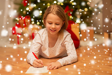 Image showing smiling girl writing christmas wish list at home