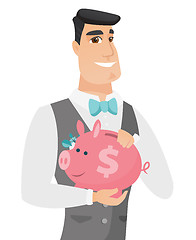 Image showing Caucasian groom holding a piggy bank.