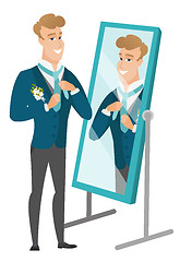 Image showing Groom looking in the mirror and adjusting tie.