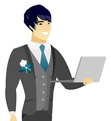 Image showing Young asian groom using a laptop.
