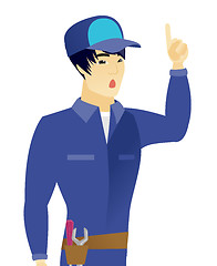 Image showing Asian mechanic with open mouth pointing finger up.