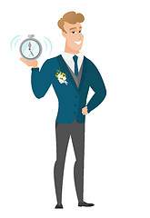 Image showing Caucasian groom holding alarm clock.