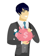 Image showing Young asian groom holding a piggy bank.