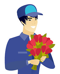 Image showing Young asian mechanic holding a bouquet of flowers