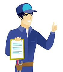 Image showing Asian mechanic with clipboard giving thumb up.