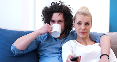 Image showing Young couple on the sofa watching television