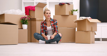 Image showing woman with many cardboard boxes sitting on floor