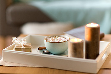 Image showing hot chocolate, christmas gift and candles on table