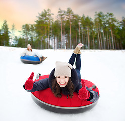 Image showing happy teenage girl sliding down hill on snow tube