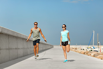 Image showing happy couple warming up on pier before training