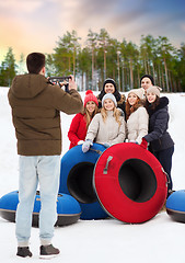 Image showing friends with snow tubes taking photo by tablet pc