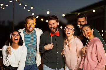 Image showing happy friends with party props at rooftop