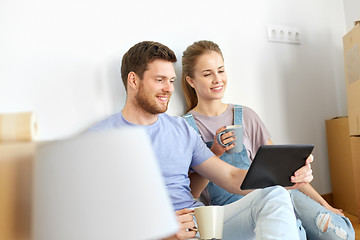 Image showing couple with tablet pc computer moving to new home