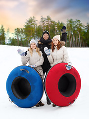 Image showing happy friends with snow tubes outdoors in winter