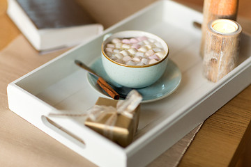 Image showing hot chocolate, christmas gift and candles on table