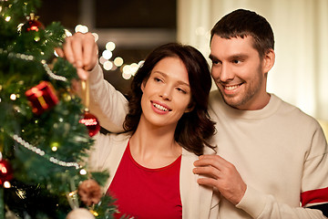 Image showing happy couple decorating christmas tree at home