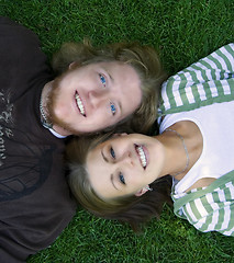 Image showing Young couple looking at the camera laying down