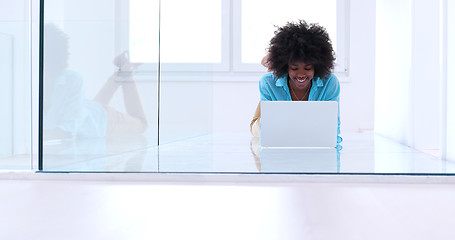 Image showing black women using laptop computer on the floor