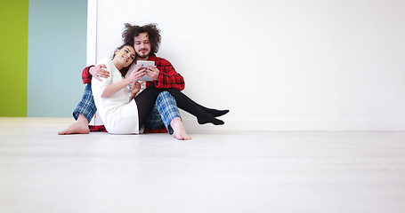 Image showing Young Couple using digital tablet on the floor