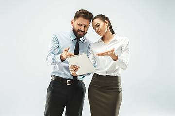 Image showing a business man shows the laptop to his colleague in the office.