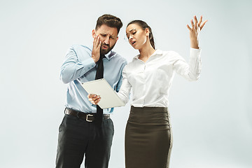 Image showing a business man shows the laptop to his colleague in the office.