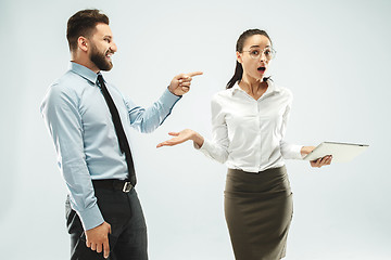 Image showing a business man shows the laptop to his colleague in the office.