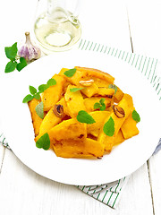 Image showing Pumpkin with garlic and mint in plate on board