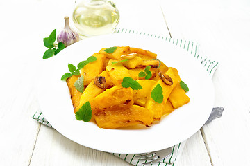 Image showing Pumpkin with garlic and mint in plate on light board