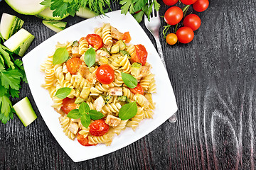 Image showing Fusilli with chicken and tomatoes in plate on black board top