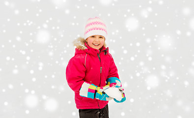 Image showing happy little girl playing with snow in winter