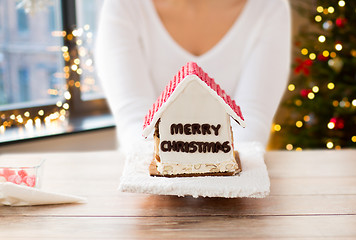 Image showing close up of woman with christmas gingerbread house