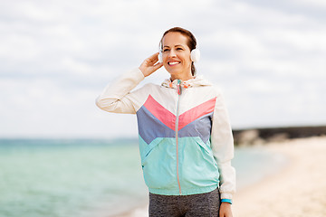 Image showing sporty woman with headphones on beach