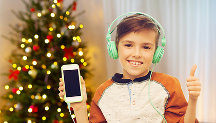 Image showing boy with smartphone and headphones on christmas