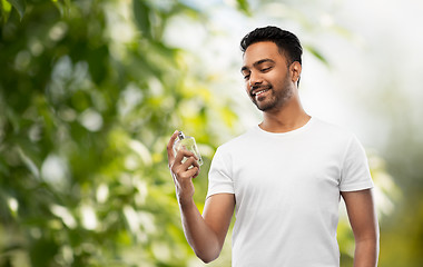 Image showing indian man with perfume over natural background