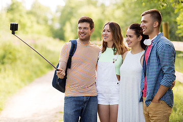 Image showing friends take picture by smartphone on selfie stick