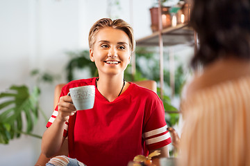 Image showing female friends drinking coffee and talking at cafe