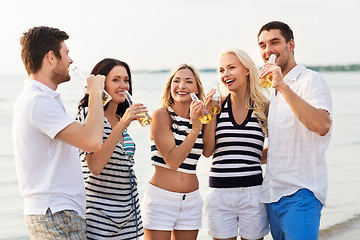 Image showing happy friends drinking non alcoholic beer on beach