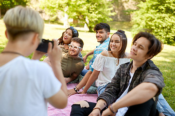 Image showing friends photographing at picnic in summer park