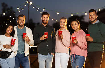 Image showing friends with party cups on rooftop at night