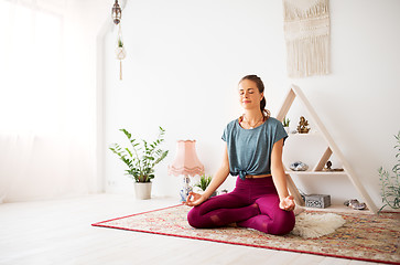 Image showing woman meditating in lotus pose at yoga studio