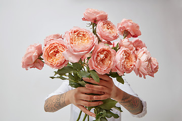 Image showing bouquet of fresh pink roses, holding a girl