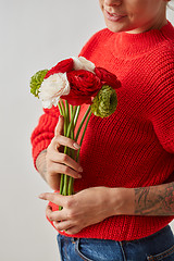 Image showing A fresh bouquet of flowers Ranunculus in the hands of a woman on a gray background. Card