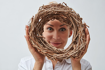 Image showing Smiling girl with a wreath of twigs