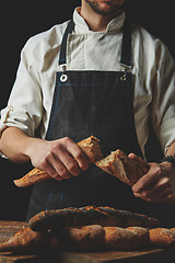 Image showing Halved baguette in the hands of a baker