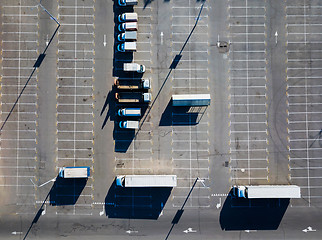 Image showing Aerial view from a drone of a parking lot with a multitude of trucks on a sunny day. Top view