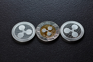 Image showing Three silver ripplecoins isolated on a dark background. Cryptocurrency and blockchain trading concept. Top view