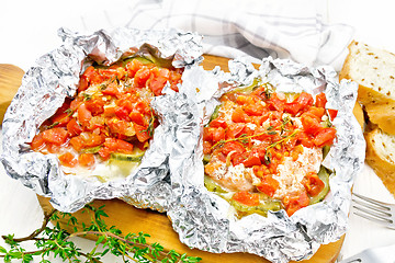 Image showing Salmon with vegetables in foil on board